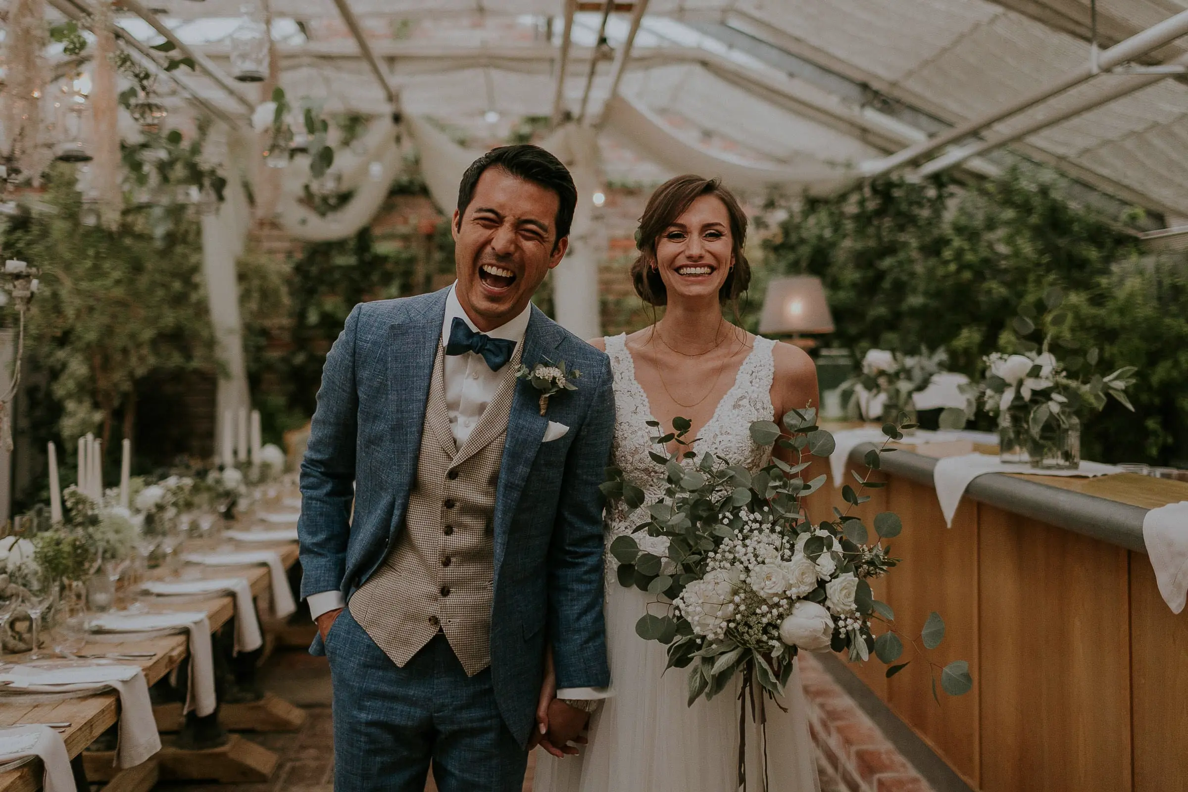 Ein Brautpaar freut sich und lacht in die Kamera am Tag Ihrer Hochzeit