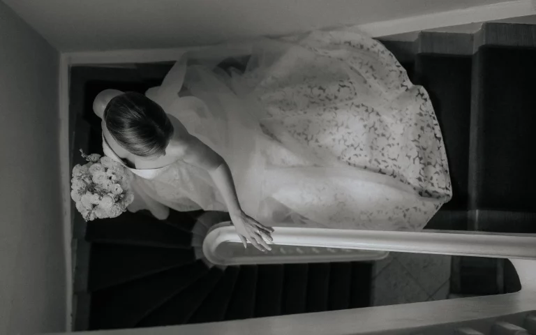 Eine Braut geht in der Hochzeitslocation La Villa am Starnberger See die Treppe hinunter zur freien Trauung