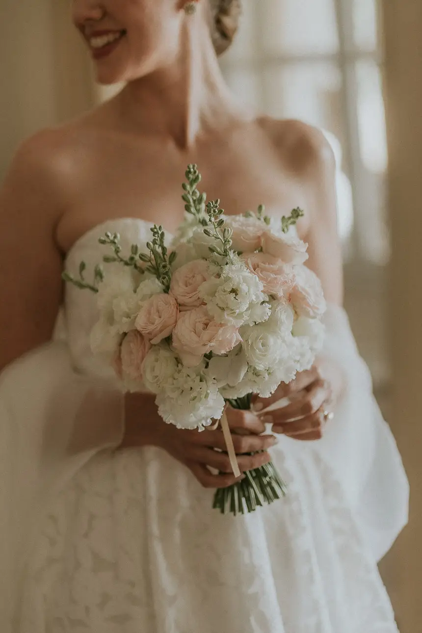 Hochzeitsfoto einer lachenden und glücklichen Braut mit Ihrem Brautstrauß an Ihrer Hochzeit in München